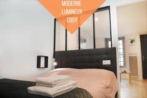 una camera da letto con un letto e asciugamani di Self Checkin Automatique - 9 min Disney - LE ZEN - COSYRENTING a Villeneuve-le-Comte