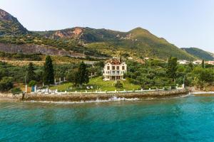 a large white house on a island in the water at Villa Filoxenia - by the sea - up to 12 guests in Kato Rodini