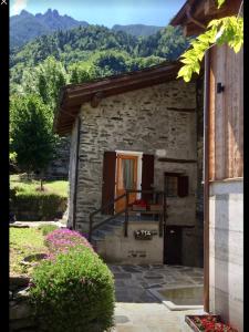 a small stone building with a staircase and a window at LA GRAA in Piuro