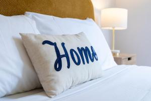a pillow with the word home on it sitting on a bed at Lotus Stay Manly - Apartment 31G in Sydney