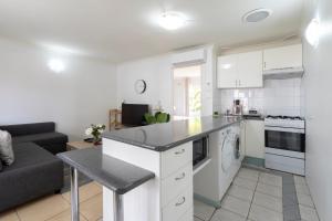 a kitchen with a counter top and a living room at Lotus Stay Manly - Apartment 31G in Sydney