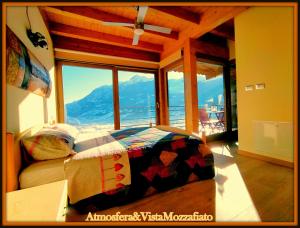 a bedroom with a bed in front of a large window at Atmosfera e vista mozzafiato Chalets in Aosta