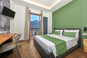 a bedroom with a bed and a desk and a window at Hotel Al Rio Se in Limone sul Garda