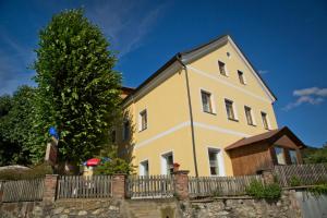 una gran casa amarilla con una valla en Pension Lindenhof, en Deutschfeistritz