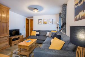een woonkamer met een bank en een tv bij Simply Morzine - Apartment des Montagnes in Morzine