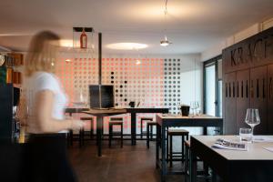 a woman standing in a restaurant with tables and chairs at KRACHER Ferienhaus No 2 - inklusive Pool in Illmitz