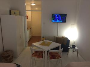 a living room with a table and a tv on the wall at Studio apatrman Pijalović in Bjelovar