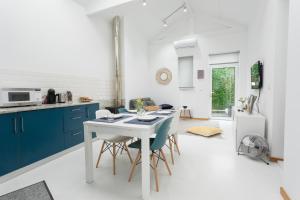una cocina con armarios azules y una mesa con sillas en Casa da Porta Azul, en Aveiro