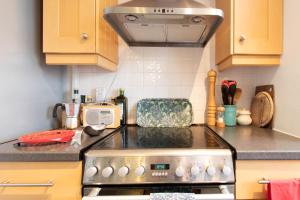 a kitchen with a stove top oven in a kitchen at Pass the Keys - Putney Hidden Gem & Free Parking in London