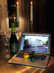 a laptop computer sitting on a table next to a bottle of wine at Hotell Värend in Växjö