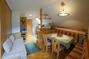 Gasthof zur Gams في دونيغسباشوالد: مطبخ وغرفة معيشة مع طاولة وأريكة