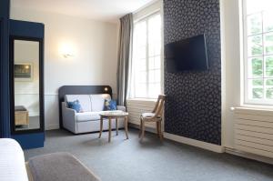 a living room filled with furniture and a tv at Anne D'anjou Hôtel & Spa in Saumur