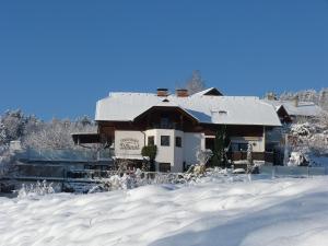 une maison avec de la neige devant elle dans l'établissement Ferienhaus Blümel inkl. freier Strandbadeintritt, à Velden am Wörther See