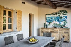 a dining room table with a bowl of fruit on it at Borgo Smeraldo Villas in Arzachena