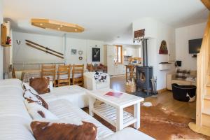 a living room with a white couch and a table at Simply Morzine - Chalet Coeur de Morzine in Morzine