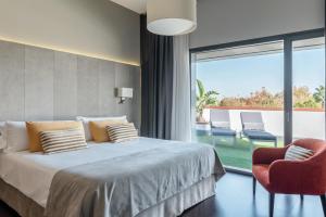 a bedroom with a bed and a large window at Sevilla Green Suites in Alcalá de Guadaira