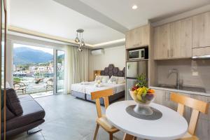 una cucina e un soggiorno con letto e tavolo di Akrogiali Apartments a Balíon