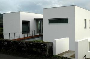 een wit huis met een balkon ervoor bij Casa da Ribeira in Lajes do Pico