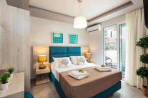 a bedroom with a large bed with a blue headboard at Akrogiali Apartments in Balíon