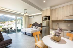 a kitchen and living room with a bed and a table at Akrogiali Apartments in Bali