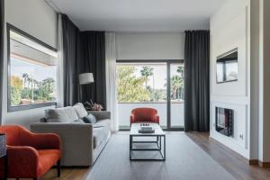 アルカラ・デ・グアダイラにあるSevilla Green Suitesのリビングルーム(ソファ、椅子付)