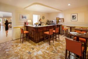 a woman in a kitchen with a counter and chairs at Hotel Villa Ida family wellness in Laigueglia