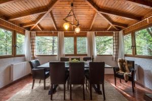 a dining room with a table and chairs and windows at Villa Parnassos in Kalívia