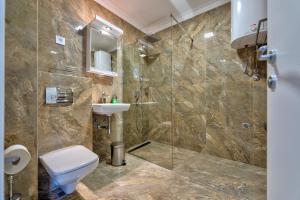 a bathroom with a toilet and a sink and a shower at Onix Residence in Zlatibor