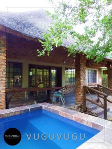 a swimming pool in front of a house at VuguVugu - At home in Africa in Marloth Park
