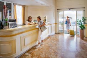 two women standing at a counter at a salon at Hotel Villa Ida family wellness in Laigueglia
