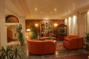 un vestíbulo con 2 sillas naranjas y TV en Hotel Smeraldo, en Lido di Jesolo