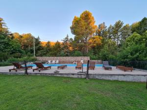 um grupo de bancos sentados em torno de uma piscina em La Barraca Resort em Merlo