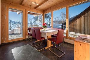 a dining room with a table and chairs and windows at Apartment Eisacktal in Mühlbach