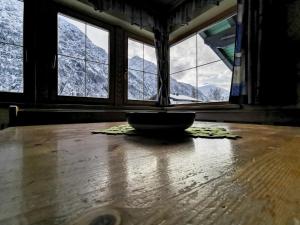 a bowl on a wooden floor in front of windows at Appartment Sonnenkogel in Holzgau