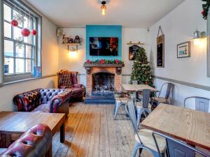 een woonkamer met een open haard en een kerstboom bij George & Dragon Inn in Chichester