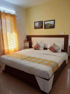 a bedroom with a large bed with two pillows at Brown Tree Resorts in Ooty