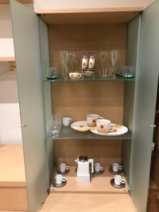 a cupboard with cups and saucers and a tea set at O recuncho in Monforte de Lemos