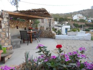 a patio with a table and chairs and flowers at Το σπίτι του Παππού. in Patmos