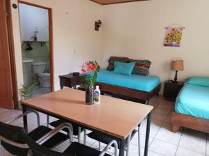 sala de estar con mesa y cama en Cahuita Lodge en Cahuita