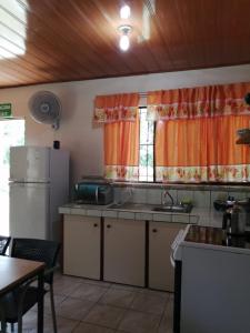 cocina con fregadero, nevera y ventana en Cahuita Lodge en Cahuita