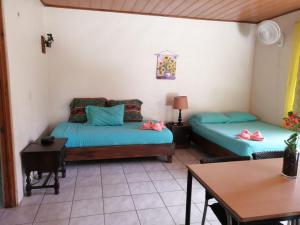 Habitación con 2 camas y mesa. en Cahuita Lodge en Cahuita