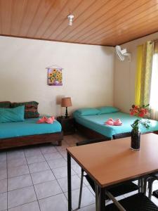 Sala de estar con 2 camas y mesa en Cahuita Lodge en Cahuita
