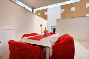 a red dining room with a white table and red chairs at Apartment Village Nin in Nin