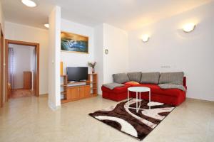 a living room with a red couch and a tv at Apartment Village Nin in Nin