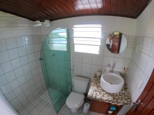 uma casa de banho com um chuveiro, um WC e um lavatório. em Casa dos Tubarões em Fernando de Noronha