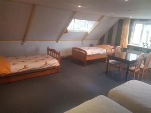 een slaapkamer met 2 bedden en een tafel en stoelen bij Wilhelminahoeve in Tiendeveen