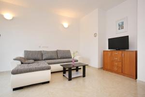 a living room with a couch and a tv at Apartment Village Nin in Nin