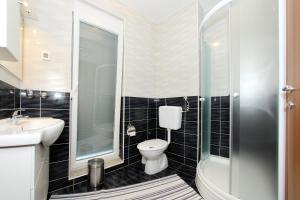 a bathroom with a toilet and a sink and a shower at Apartment Village Nin in Nin