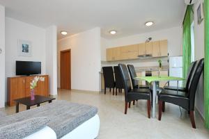 a living room with a table and chairs and a kitchen at Apartment Village Nin in Nin