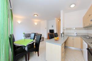 a kitchen and dining room with a table and chairs at Apartment Village Nin in Nin